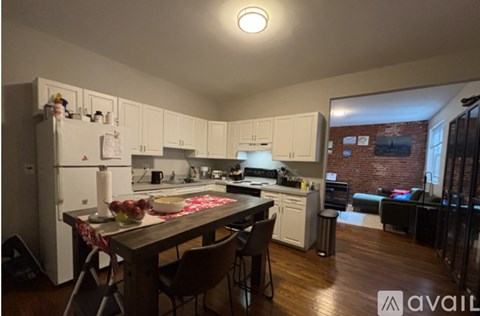 A kitchen with a table set for two with a red and white tablecloth.
