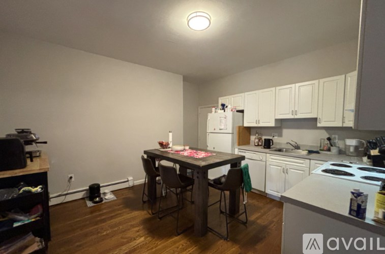 A kitchen with white cabinets and a table with chairs.