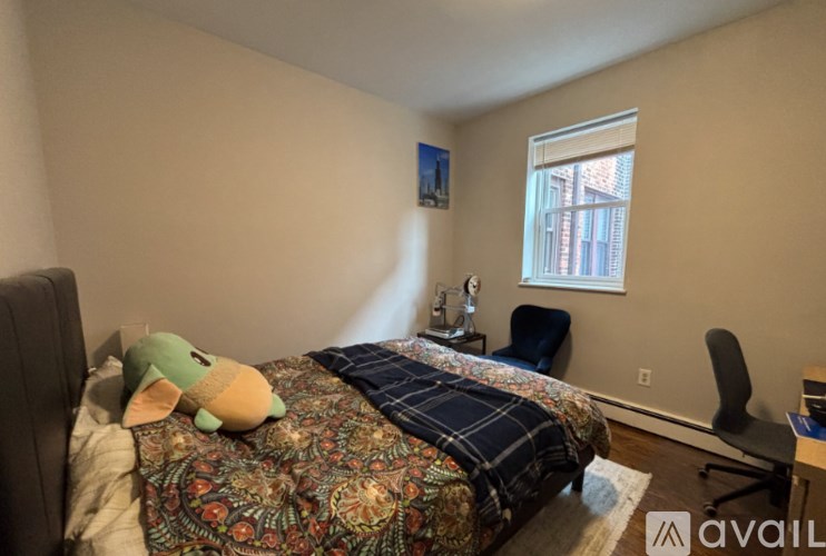 A bedroom with a bed, a chair, and a window.