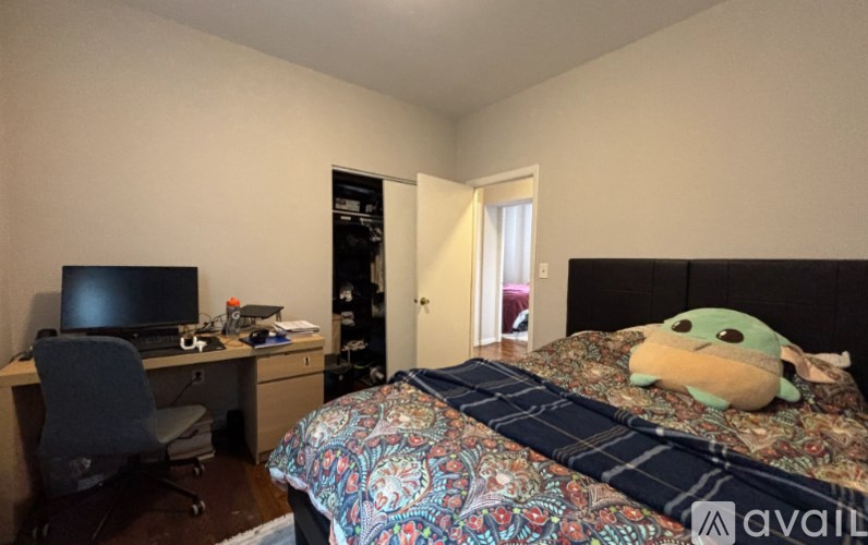 A bedroom with a bed, desk, and chair.