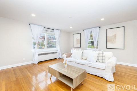 A living room with a white couch and a wooden coffee table.