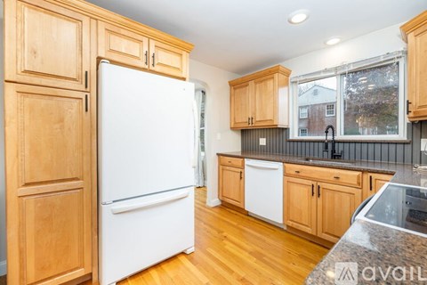 A kitchen with wooden cabinets and a white refrigerator.