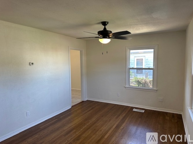A room with a ceiling fan and a window.