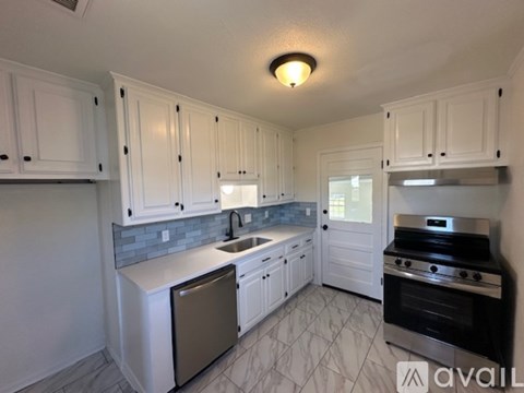 A kitchen with white cabinets and a black stove top oven.