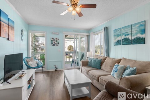 A living room with a brown couch and a ceiling fan.