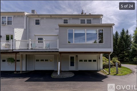 A two-story house with a balcony and a garage is for sale.