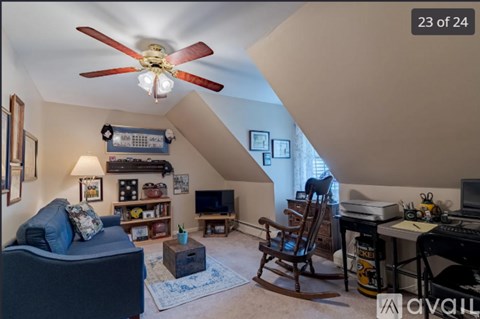 A living room with a blue couch and a ceiling fan.
