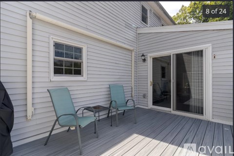 A small porch with a table and two chairs.