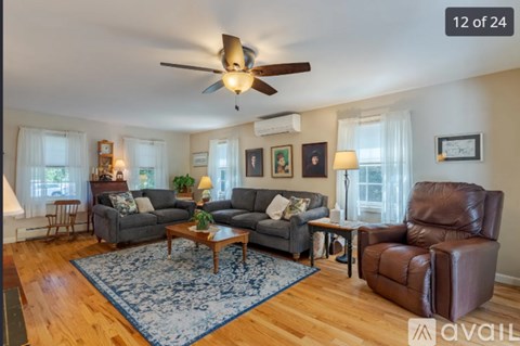 A living room with a brown leather chair and a blue rug.
