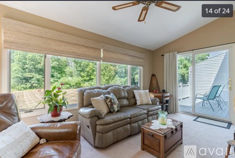 A living room with a brown leather couch and a wooden coffee table.