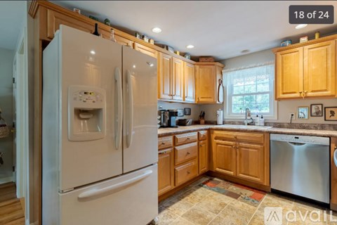 A kitchen with wooden cabinets and a white fridge.