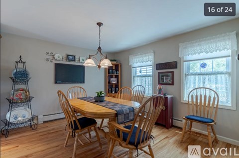 A dining room with a wooden table and chairs.