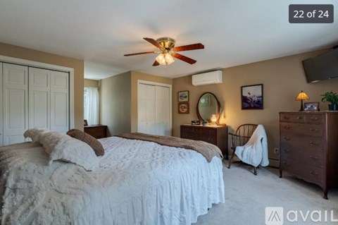A bedroom with a large bed and a ceiling fan.