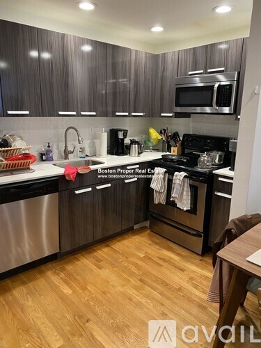 A kitchen with wooden floors and stainless steel appliances.