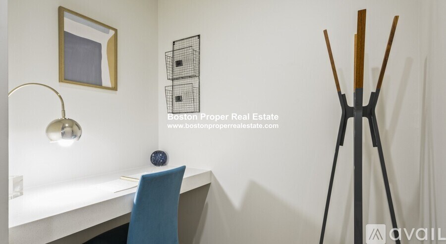 A room with a desk, chair, and a lamp.