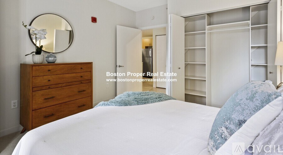 A bedroom with a bed, dresser, and mirror.