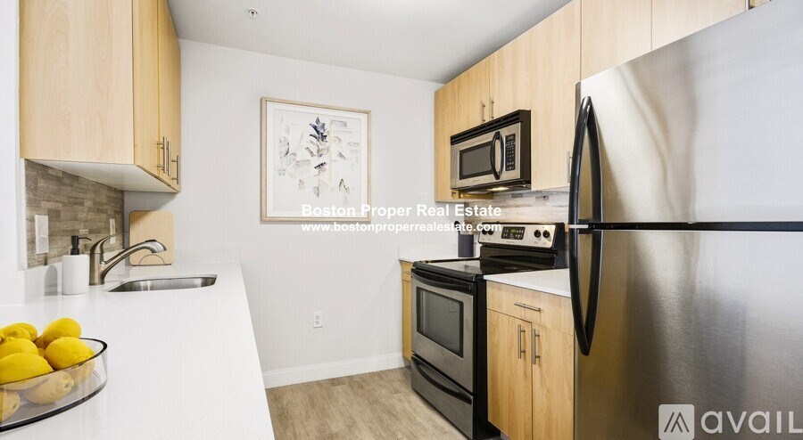A kitchen with wooden cabinets and a stainless steel refrigerator.