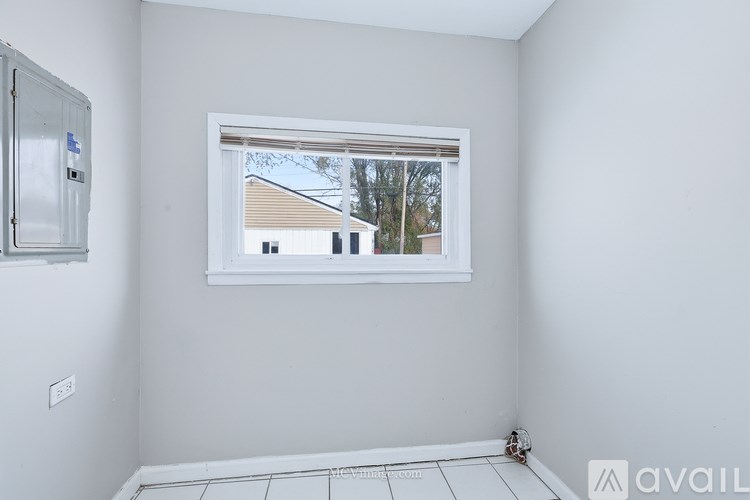 A room with a window showing a view of a building outside.
