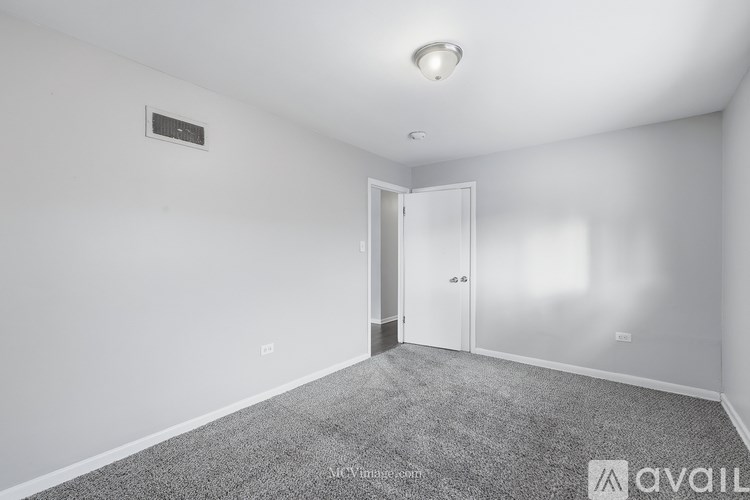 A room with a carpeted floor and a white door.