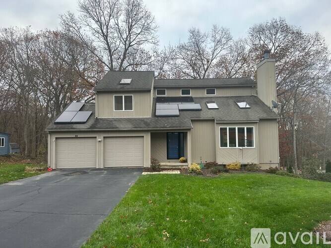 A house with solar panels on the roof and a driveway in front.
