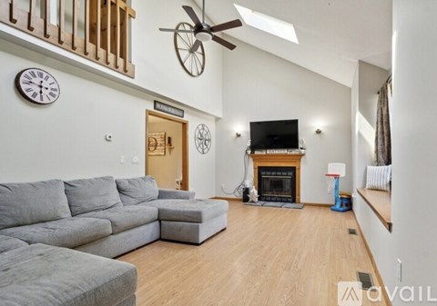 A living room with a grey couch and a fireplace.