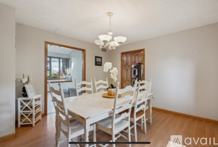 A dining room with a white table and chairs.