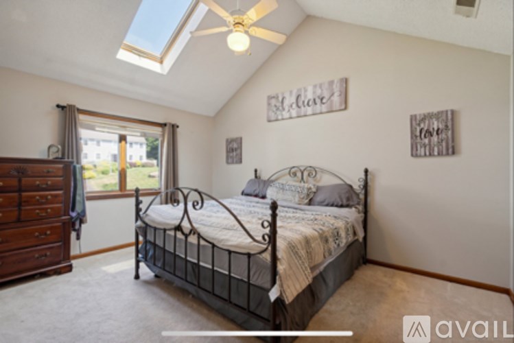 A bedroom with a bed, dresser, and window.