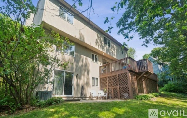 A modern two-story house with a balcony and a deck.