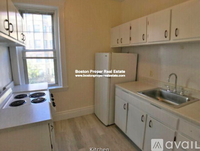 A kitchen with a stove, sink, and cabinets.