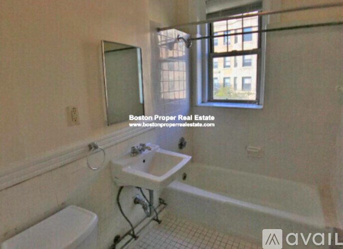 A bathroom with a tub, toilet and sink.