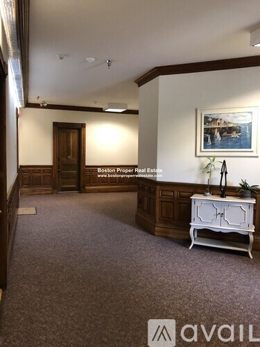 A room with a Boston Proper Real Estate sign on the wall.