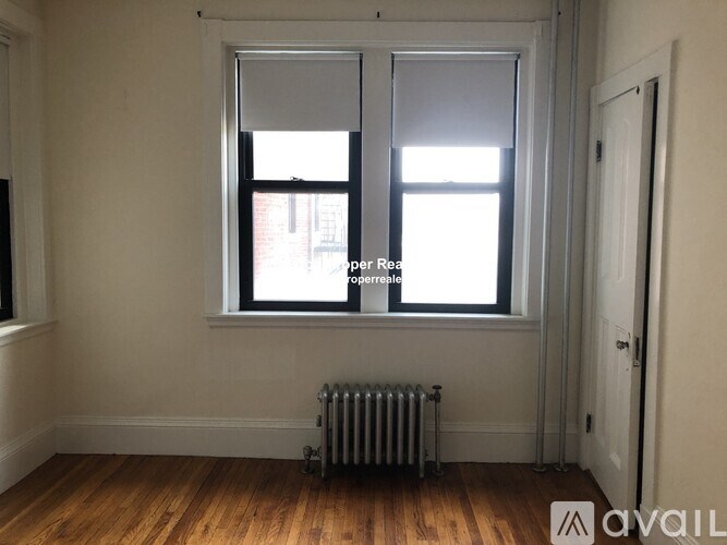 A room with a window and a radiator on the floor.