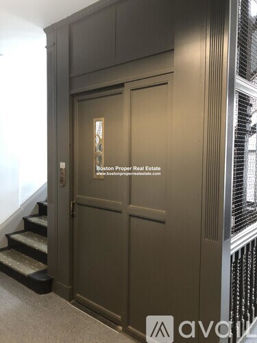 A set of stairs leads to a door with a window above it.