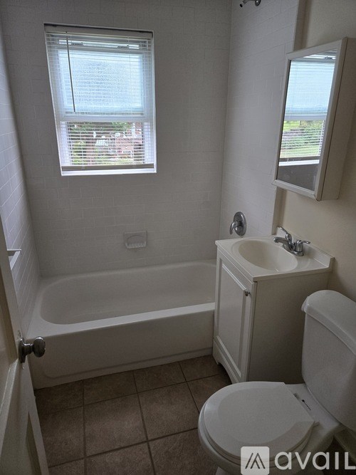 A bathroom with a tub, toilet and sink.
