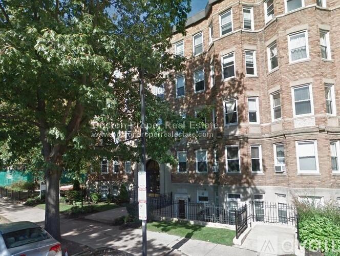 A tree in front of a building with a sign that says "Brookfield Real Estate".