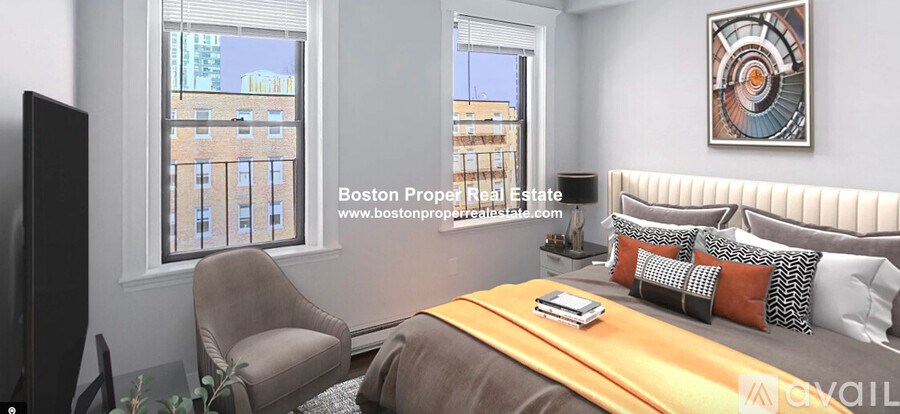 A bedroom with a bed, chair, and window overlooking a city.