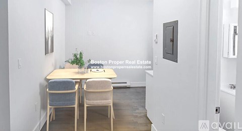 A dining room with a table and chairs.