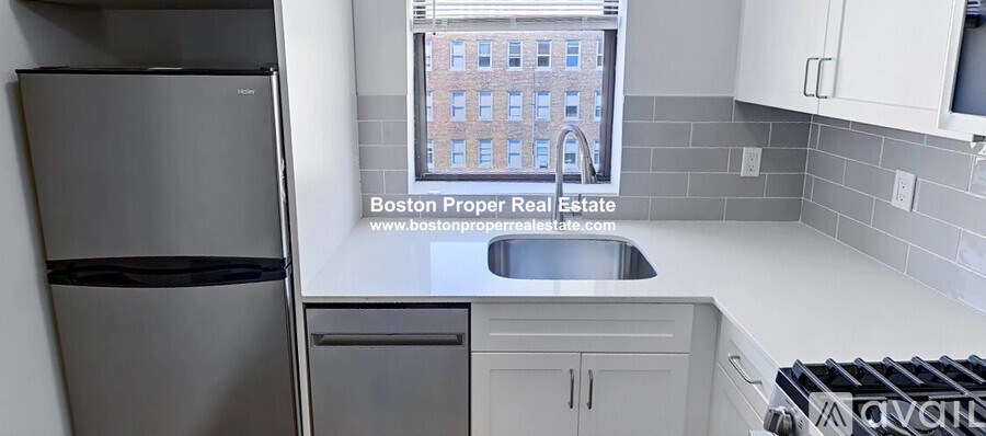 A kitchen with a window overlooking a building.