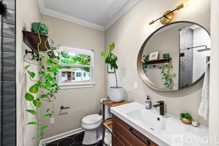 A bathroom with a white toilet, a white sink, and a mirror.
