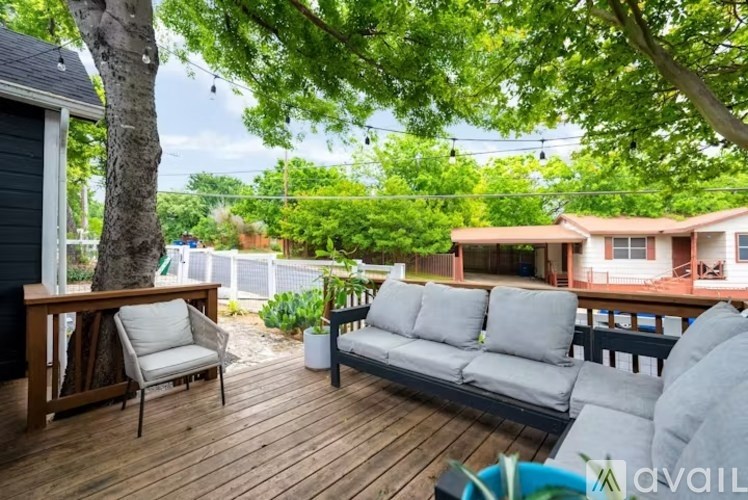 A wooden deck with a grey sofa and a chair.