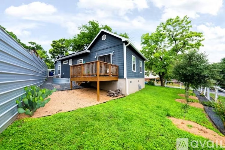 A house with a blue exterior and a wooden deck.
