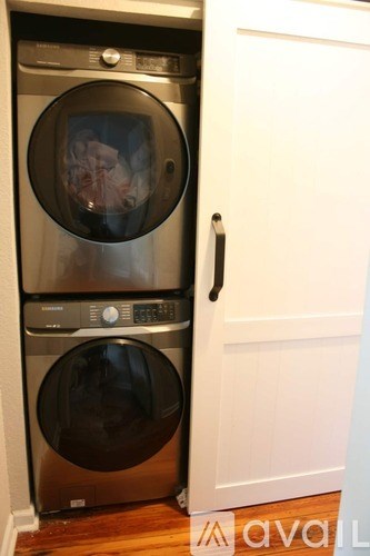 A stack of two washing machines in a small room.