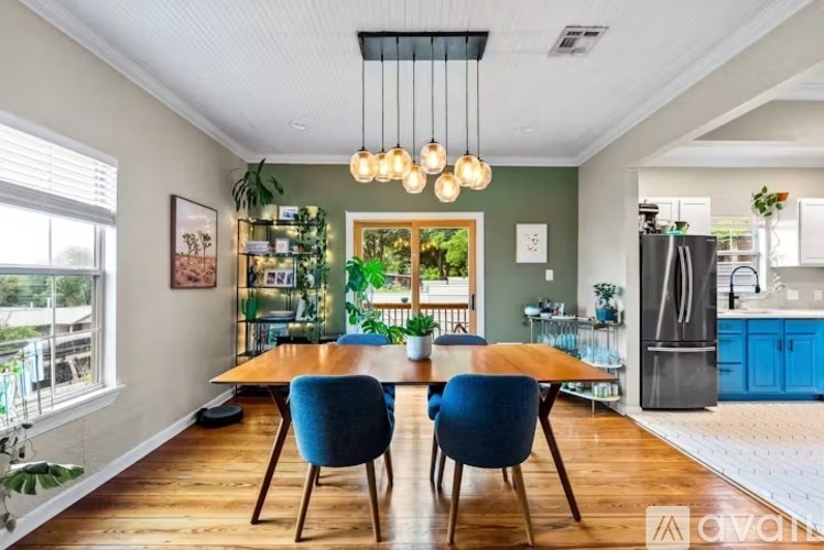 A dining room with a wooden table and blue chairs.
