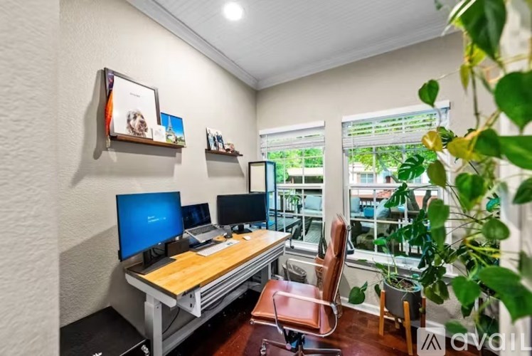 A home office with a desk, two monitors, and a chair.