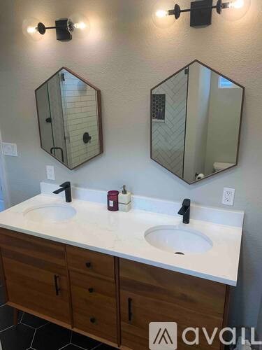 A bathroom with two sinks and two mirrors above them.