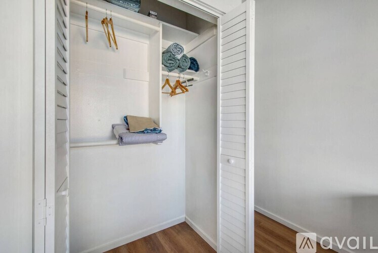A white closet with a towel and a pair of scissors hanging on the hook.