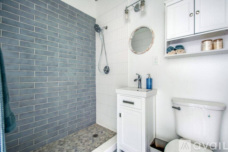 A bathroom with a white sink and a white toilet.
