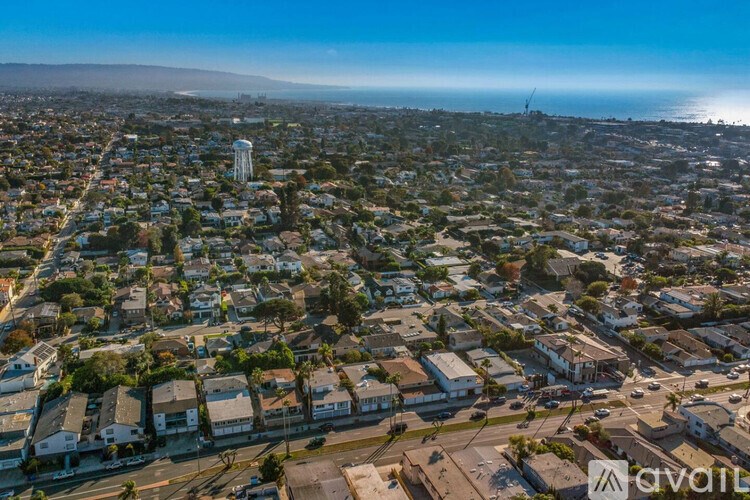 A bird's eye view of a residential area with houses and a clear blue sky.