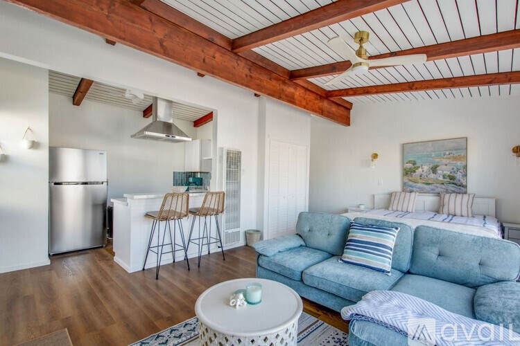 A living room with a blue couch and a wooden ceiling.
