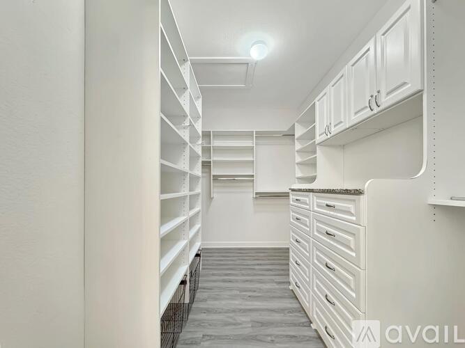 A white walk-in closet with shelves and drawers.